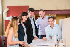 Members of Margittai Architects around a drafting table